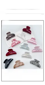 Detailed view of large acrylic claw clips with sparkling rhinestone heart accents