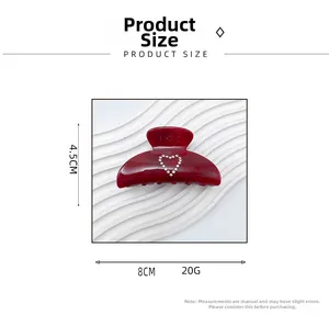 Macro shot showing dimensions of 8cm x 4.5cm for the dark red heart acrylic hair claw