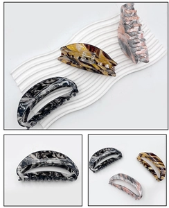 Détail de grandes pinces à cheveux en acrylique aux motifs marbrés et écaille de tortue