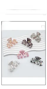 Detail view showing six colorful acetate geometric claw clips with marble textures