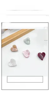 Detail von fünf herzförmigen Acryl-Haarclips mit Marmortextur in verschiedenen Pastellfarben