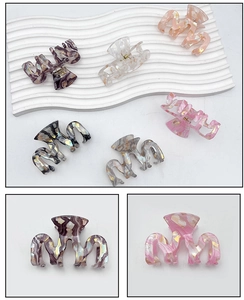 Close-up of acetic acid hair claw clip with marble ink texture and gold foil flakes