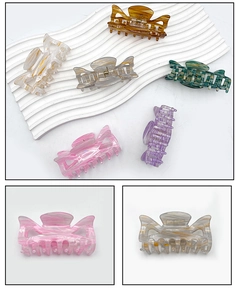 Detailed macro view of acrylic medium hair claw clips with marble texture and metal spring