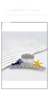 Detail view of acetate ocean-themed shark hair clips with seashell and starfish motifs