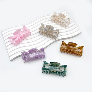 Hollow bow acrylic hair claw clips in various marbled colors displayed on a white background