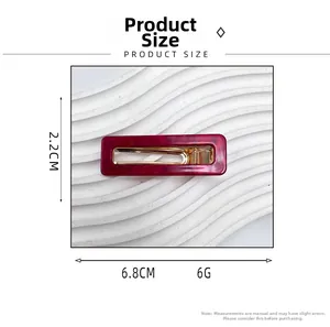 Détail de la pince à cheveux en acrylique marbré rouge avec dimensions 6,8 cm par 2,2 cm