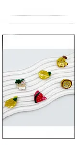 Detailed close-up of colorful acrylic fruit hair claw clips on a white display stand
