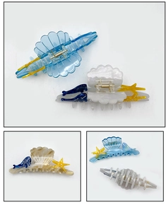 Detailed macro view of ocean-themed starfish shell and dolphin acetate hair claw clips