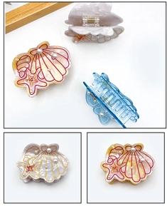 Détail de pinces à cheveux en acétate sur le thème marin avec coquillage et étoile