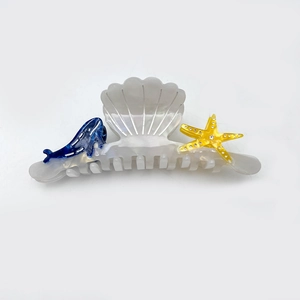 Elegant ocean-themed acetate hair claw featuring shell, blue whale, and yellow starfish
