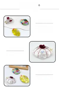 Detail of seashell-shaped hair claws with cartoon smiley and miniature fruit accents