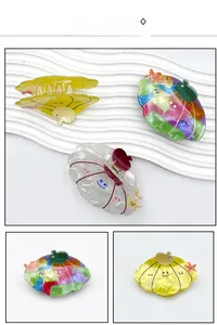 Detailed view of colorful shell-shaped acrylic hair claws with cute smile face patterns