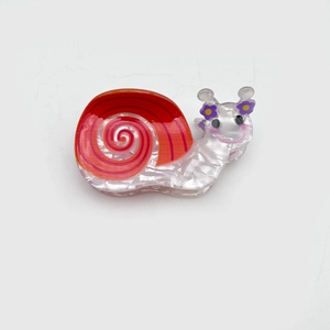 Creative snail shaped hair claw clip in orange and white acetate with purple flower detail