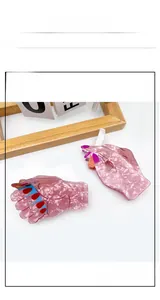 Detailed view of pink pearlescent hand-shaped acrylic hair claw clips with colorful nails