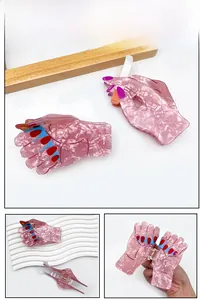 Macro detail of unique pink hand-shaped hair claw clips with colorful nail art design