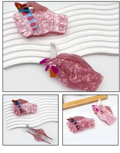 Macro detail of creative pink marble acetate hair claw showing metal spring and hand design
