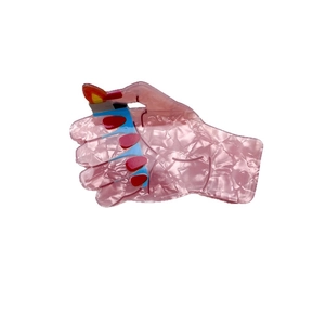 Creative hand holding lighter hair claw clip made of pink marble textured acetate