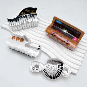 Creative music themed hair claws featuring piano, cassette, saxophone and note designs