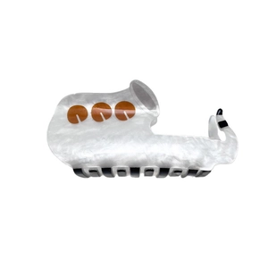 Saxophone-shaped acrylic hair claw with white marble texture and orange button details