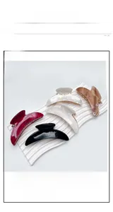 Detailed view of large crescent acrylic hair claws in five colors with marble texture