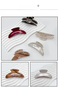 Detailed view of colorful crescent acrylic hair claws with marble and iridescent textures