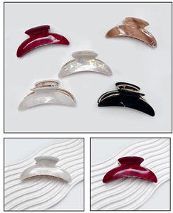 Macro detail of crescent acrylic hair claw clips in various colors with golden metal base