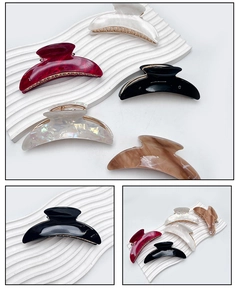 Macro details of crescent acrylic hair claws in assorted marble and pearl finishes