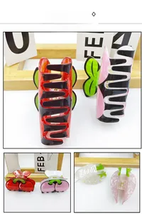 Detail view showing red and pink cherry fruit hair claws in glossy acetate material