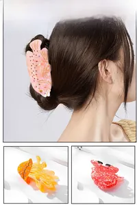 Detailed close-up of marble texture acetate hair claws with sparkling rhinestone accents