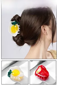 Detailed views of creative fried egg and red milk box hair claws on a female model