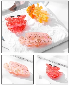 Detail view of octopus and crab hair claws featuring marble texture and rhinestones