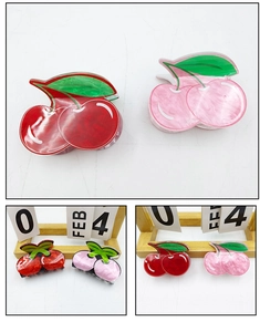 Detail of cherry hair claw clips in red and pink with glossy marble finish texture