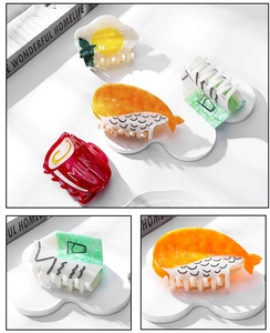 Detail view of acetate food-themed hair claws including sushi and fried egg shapes
