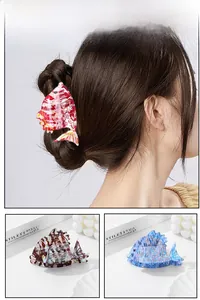 Detailed view of fish-shaped acetate hair claws with striped patterns and scale textures