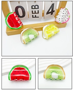 Detail of vibrant fruit-shaped hair claws featuring watermelon and kiwi designs