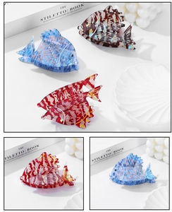 Detailed close-up of colorful acetate goldfish hair claws with glossy marble texture