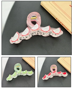 Detail of fruit-themed hair claw clips in dragon fruit, kiwi, and watermelon patterns