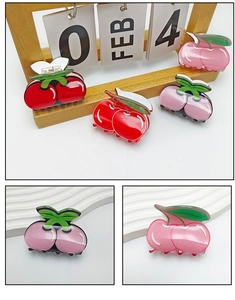 Detail view of acrylic cherry hair claws in pink and red with spring mechanism