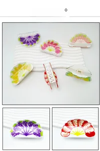 Vue détaillée de pinces à cheveux en acrylique aux motifs colorés de fraises et de raisins