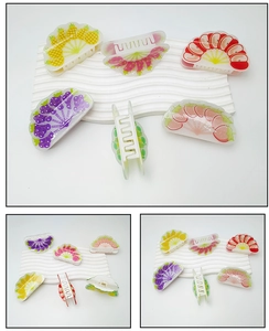 Vues détaillées de pinces à cheveux en acrylique avec motifs de pommes et de fraises