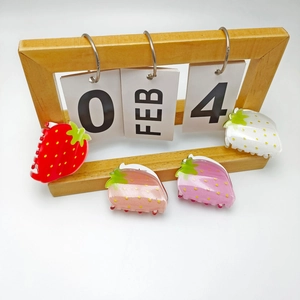 Creative strawberry shaped hair claws in red and pink colors displayed on a white background