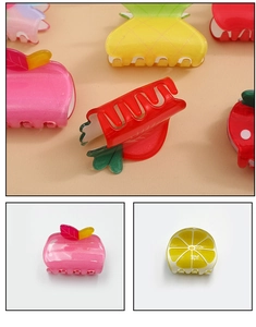 Détail de pinces à cheveux en résine pailletée aux formes d'ananas, fraise et citron