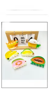 Detailed top view of large acrylic hair clips with vibrant tropical fruit patterns