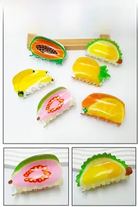 Detail shot of acrylic fruit hair claws featuring pineapple and papaya printed patterns