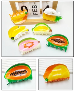 Detail of colorful acrylic fruit hair clips showing translucent textures and metal springs