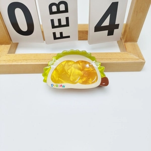 Detailed view of an acrylic durian shaped hair claw clip with colorful DURIAN lettering