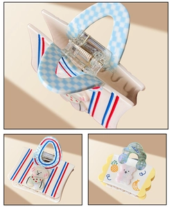 Detail showing handbag-shaped hair claws with cute patterns and premium acetate finish