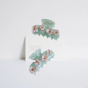 Pince à cheveux élégante en marbre vert menthe avec fleurs roses en strass sur fond blanc