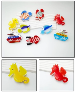 Close-up detail of sea-themed acrylic hair clips featuring colorful seahorse and fish prints