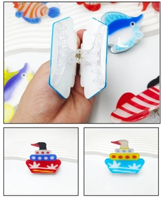 Detailed view of nautical acrylic hair claws featuring clownfish and ship shapes